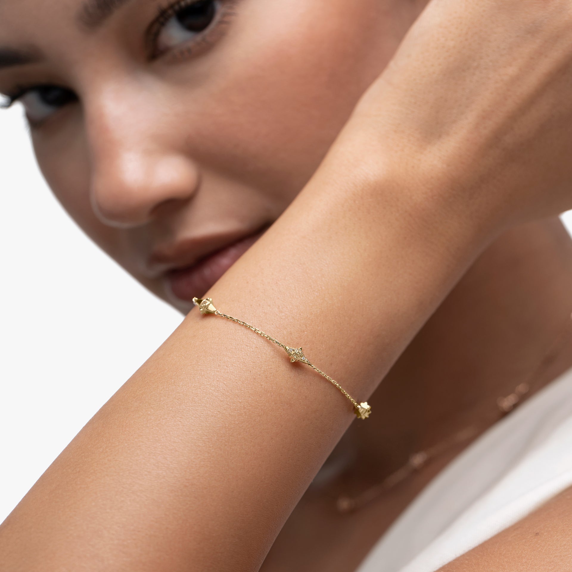 Close-up of a woman's arm wearing a Hab El Hayl gold bracelet on a white background