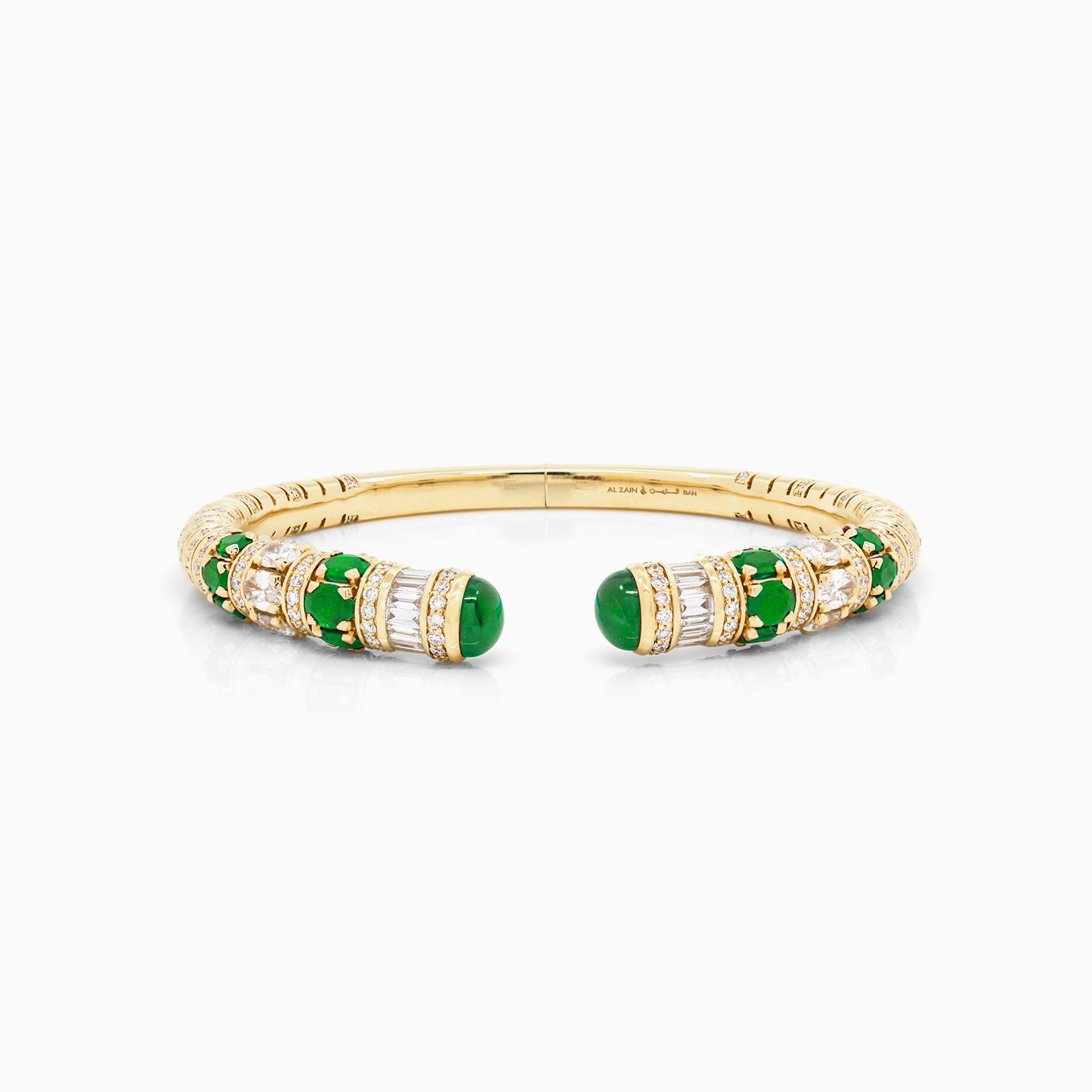 Al Zain Mushaabak 18k gold clasp bangle with green emerald gemstones set with baguette cut diamonds on a white background